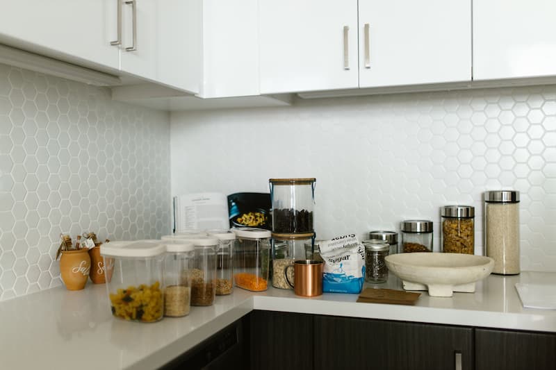 Organized kitchen counter with labeled storage containers, jars, and pantry essentials